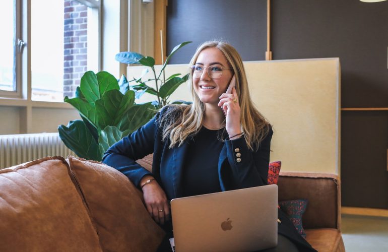 woman in blue long sleeve shirt using silver macbook